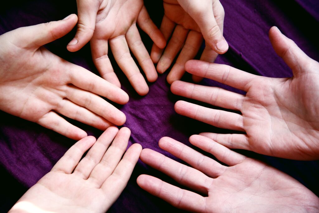A circle of hands on a purple background